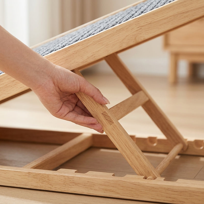 A hand setting the wooden pet ramp's support leg into a higher notch to adjust the height